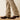 Ariat M4 Relaxed Grizzly Boot Cut Jean in Cedar Brown — boot cut hem over cowboy boots. Detail view.