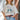 Eesome American Cowgirl Club graphic tee in Bone — oversized fit with elbow-length sleeves. Front on-model outdoors.