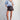 Eesome polka dot satin blouse in Powder Blue — satin button-down styled with faux leather shorts. Full-length on-model.