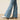 Ariat Hasley Boot Cut Jean in Porto — boot cut hem over boots. Detail view.