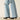 Ariat Tomboy Wide Leg Jean in Zuma — wide leg hem over boots. Detail view.