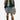 Circle A Western and Work girl wearing a light wash denim skirt, denim jacket, and floral cowboy boots in a field.