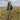 Circle A Western and Work girl wearing a Wrangler denim skirt, jean jacket, and floral cowboy boots in a field